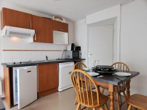 a kitchen with a table and chairs and a kitchen with a table and a kitchen at Studio moderne à Ax-les-Thermes, 30 m² avec sauna in Ax-les-Thermes