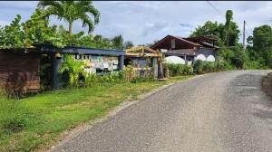 an empty road next to a village with a store at Bungalow cosy à Sainte-Anne avec jardin in Sainte-Anne
