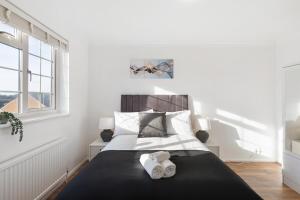 a bedroom with a bed with two towels on it at Garden Parking WiFi Near Sky Elstree Studios in Elstree