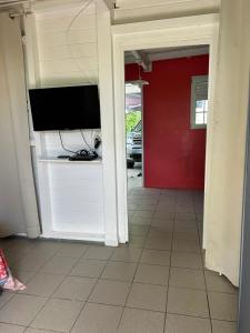 - un salon avec une télévision et une porte rouge dans l'établissement Appartement confortable à Baie-Mahault, 35 m² avec terrasse, à Baie-Mahault 11 autres photos