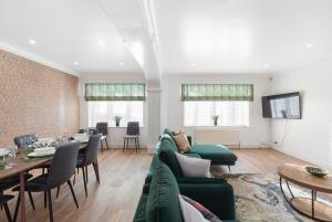 a living room with a green couch and a table at Garden Parking WiFi Near Sky Elstree Studios in Elstree