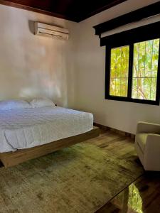 een slaapkamer met een bed en twee ramen bij Private Guesthouse near Airport in San Pedro Sula
