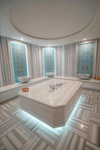 a large white tub in a room with two windows at Aqua Raj ND in Novi Pazar