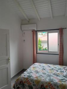 un dormitorio con una cama y una ventana en Appartement spacieux à Morne-à-l'Eau, 80 m², piscine privée, en Brion