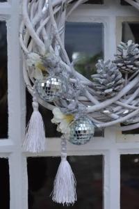 Un oiseau est posé sur une couronne de fleurs à une fenêtre. dans l'établissement Villa charmante à Arsac avec piscine privée et jardin, à Arsac