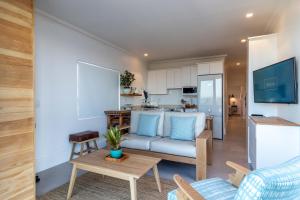 a living room with a couch and a kitchen at Oceans Guest House & Luxurious Apartments in Struisbaai