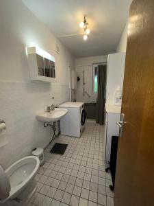 a bathroom with a toilet sink and a washing machine at detached bungalow, 5 beds wifi smart tv terras 3 parkings keybox in Emlichheim