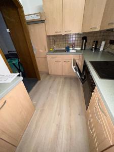 a kitchen with wooden cabinets and a wooden floor at detached bungalow, 5 beds wifi smart tv terras 3 parkings keybox in Emlichheim +10 photos
