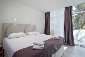 a bedroom with a large bed and a large window at Hotel Emaus in Novigrad Istria +96 photos