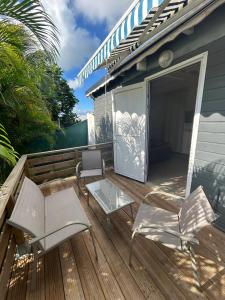 une terrasse avec deux chaises, une table et des chaises dans l'établissement Appartement confortable à Baie-Mahault, 35 m² avec terrasse, à Baie-Mahault