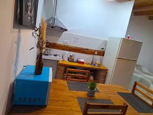 a small kitchen with a table and a refrigerator at departamento por dia ruta 41 3 in Los Antiguos