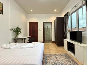 PROpaganda Guest House في تونغسالا: غرفة نوم بسرير وتلفزيون وطاولة +7 صور