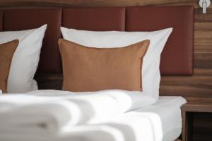 a bed with white pillows and a brown headboard at sQuare Hotel in Frankfurt/Main