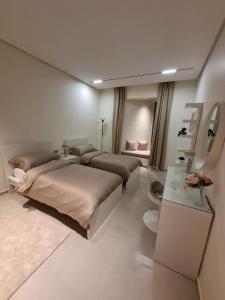 a bedroom with two beds and a table with flowers at كمباوند شقة مفروشة كومباوند الامعري المطار 222 in Amman