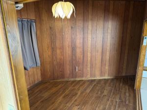 a room with wood paneling and a chandelier at 鶴岡市中心地ゲストハウス in Tsuruoka