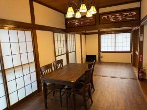 a dining room with a wooden table and chairs at 鶴岡市中心地ゲストハウス in Tsuruoka