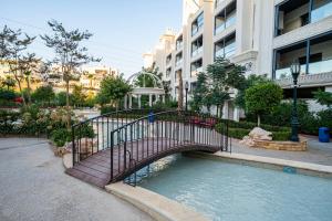 a bridge over a pool of water in a city at كمباوند شقة مفروشة كومباوند الامعري المطار 222 in Amman