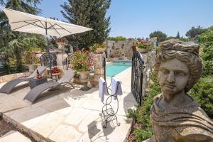 a statue of a bust next to a pool at אחוזת בר in Sha'al