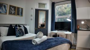 バーミンガムにあるCharming Studio in the heart of birminghamのベッド2台、机、テレビのある寝室