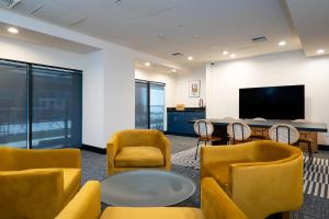 Habitación con sillas, mesa y TV. en Kasa Sunset Los Angeles, en Los Ángeles