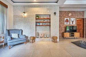 a living room with a blue chair and a brick wall at Casa Ola Villa Pererenan in Canggu