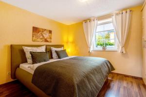 a bedroom with a large bed with a window at Pension Schmidt in Bad Brambach