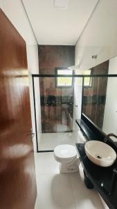 une salle de bains avec toilettes et lavabo dans l'établissement Casa com piscina - Costa do Sol, à Bertioga