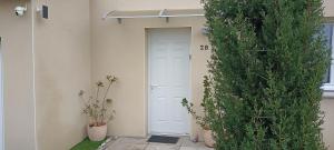 a white door in a building with two plants at Chambre privée in Montaigu-Vendée