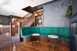 a green couch in a restaurant with a staircase at The Davis Downtown San Diego in San Diego