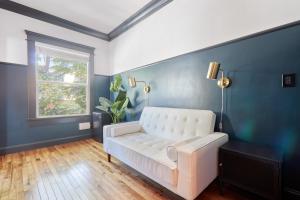 a white couch in a blue room with a window at The Davis Downtown San Diego in San Diego