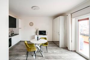 a kitchen and dining room with a table and yellow chairs at Mono Imperiale - 30 min Firenze in Prato