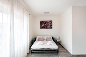 a bedroom with a bed with white sheets and pink pillows at Mono Imperiale - 30 min Firenze in Prato