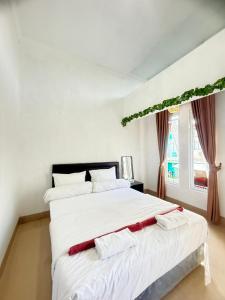 a white bedroom with a large white bed with two white pillows at Private Villa Near Nusa Dua Beach Bali in Nusa Dua