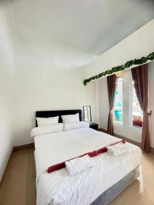 a bedroom with a large white bed with two pillows at Private Villa Near Nusa Dua Beach Bali in Nusa Dua