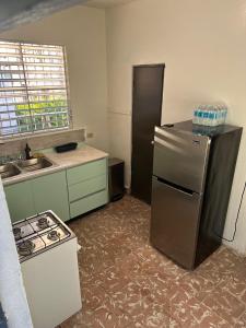 an empty kitchen with a refrigerator and a stove at King Bed Private Apartment in Ponce