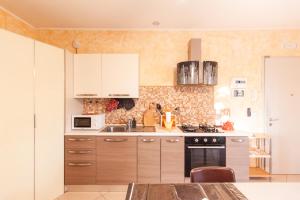 eine Küche mit weißen Schränken und einem Herd mit Backofen in der Unterkunft La casa di Graziella in Casa Boulogne