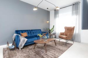 een woonkamer met een blauwe bank en een tafel bij Kasa Collins Park Miami Beach Convention Center in Miami Beach