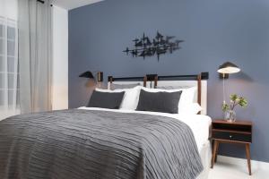 een slaapkamer met een groot bed met een blauwe muur bij Kasa Collins Park Miami Beach Convention Center in Miami Beach