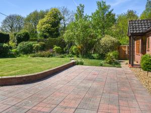 a brick driveway in a garden with a house at Dippers in Smallburgh