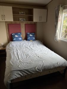 a bed in a small room with a window at Caravan With Decking At Manor Park In Hunstanton, Sleeps 8 Ref 23046B in Hunstanton +11 photos