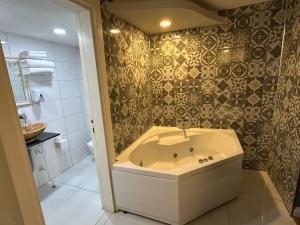 a bathroom with a bath tub and a sink at Bakırköy Otel in Istanbul
