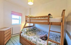 Un dormitorio con dos literas y una cómoda. en Main House at White Horses, Bantham, South Devon with panoramic sea views across to Burgh Island, en Bantham