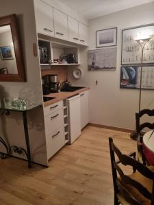 een keuken met witte kasten en een tafel. bij le Jardin in Dinard