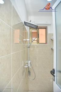 a shower with a shower head in a bathroom at Ranscilla Homes & Apartments in Tema