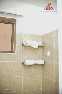 a bathroom with a shower with towels and a window at Ranscilla Homes & Apartments in Tema +29 photos