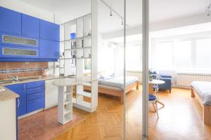 a kitchen with blue cabinets and a table at STUDIO APARTMENT SiLVER in Sarajevo