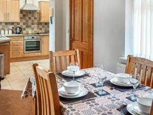 a dining room table with plates and wine glasses on it at Bwthyn Bwlch in Denbigh