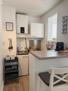 a kitchen with white cabinets and a counter top at À 1min à pied de la mer, studio lumineux & cosy in Carnon-Plage