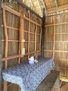 a table in a straw hut with flowers on it at Humble Homestay in Besir