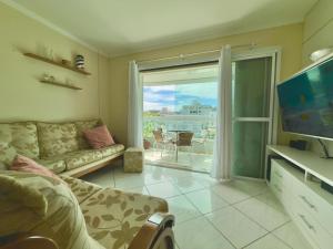 TV a/nebo společenská místnost v ubytování 3 quartos a 280m da praia c roupa de cama - Sacada com Churrasqueira - climatizado - 10 min a pé da passarela do Ribeiro e acesso a Praia de Bombinhas - 5 min a pé de supermercados - Até 8 pessoas, ideal p famílias, grupos, crianças